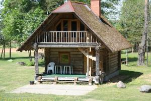 een kleine blokhut met een veranda en een terras bij Kempings Sniedzes in Ķegums