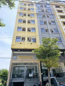 a yellow building with a sign on the front of it at Royal Apartment in Dien Ban