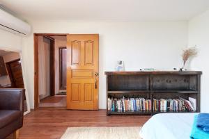 Una habitación con una cama y una estantería con libros. en Bright, Airy Itaewon Rooftop, 10 min to Myeongdong, en Seúl