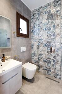 a bathroom with a toilet and a sink and a mirror at Villa Starova in Berat