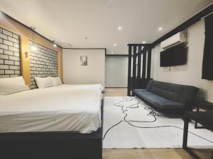a hotel room with a bed and a couch at 안온호스텔 성수건대 in Seoul