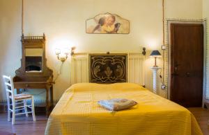 um quarto com uma cama com um cobertor amarelo em Sansepolcro Rooms Rent em Sansepolcro