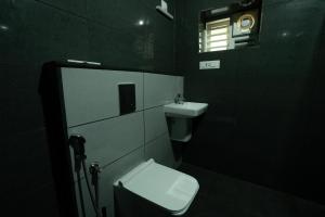 a bathroom with a toilet and a sink and a window at Villa La Vista Homestay in Calicut +20 photos