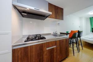 a kitchen with a sink and a stove top oven at Oakville Nezu by Tranova in Tokyo