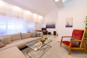 a living room with a couch and a chair at העוגן והים - The Anchor and the Sea in Shlomi
