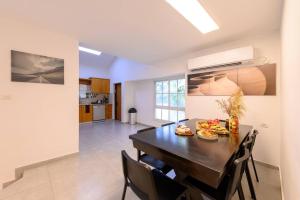 a kitchen and dining room with a table and chairs at העוגן והים - The Anchor and the Sea in Shlomi