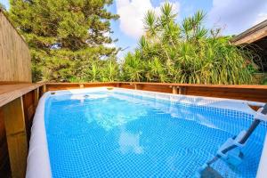 una piscina en un patio trasero con una valla de madera en העוגן והים - The Anchor and the Sea, en Shelomi