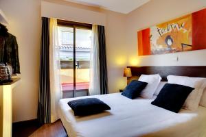 um quarto com uma grande cama branca com almofadas azuis em THC Tirso Molina Hostel em Madri