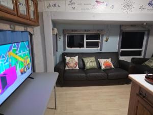 a living room with a couch and a tv at Fifth wheel in Kelso