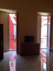 une chambre avec deux portes et une télévision sur une commode dans l'établissement Casa Luisa, à Portici