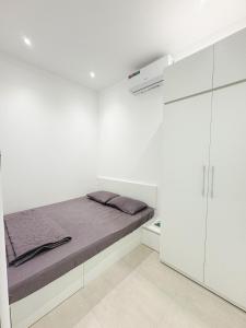 a white bedroom with a bed and white cabinets at Cozy Boutique in Buon Ma Thuot