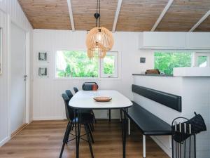 a dining room with a white table and chairs at 4 star holiday home in Bindslev in Bindslev