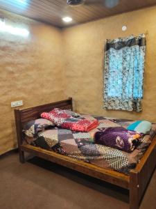 KanthalloorにあるBREEZE GARDEN MUD HOUSE Home Stayのベッドルーム1室(木製ベッド1台、窓付)
