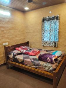 KanthalloorにあるBREEZE GARDEN MUD HOUSE Home Stayのベッドルーム1室(木製ベッド1台、窓付)
