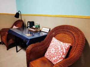 ein Raum mit einem Tisch mit einem Korbstuhl und einem Tisch in der Unterkunft Beret B & B in Tengchong