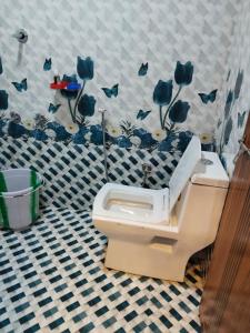 KanthalloorにあるBREEZE GARDEN MUD HOUSE Home Stayのバスルーム(青い花の壁のトイレ付)