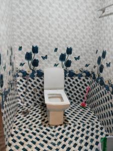 KanthalloorにあるBREEZE GARDEN MUD HOUSE Home Stayのバスルーム(青い花の壁のトイレ付) +3枚の写真