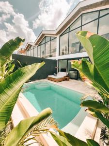 ein Haus mit einem Pool und Palmen in der Unterkunft Loket Lofts in Uluwatu
