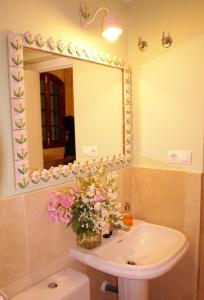 a bathroom with a sink and a mirror and flowers at Apartamento Centro Judería in Seville