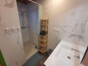 a white bathroom with a shower and a sink at Vakantie verblijf in Bredene