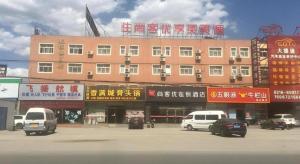 a large building with cars parked in a parking lot at Thank Inn Hotel Hebei Langfang Xianghe County Guidu Furniture Center in Jinxinzhuang