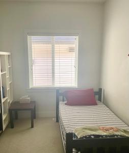ein kleines Schlafzimmer mit einem Bett und einem Fenster in der Unterkunft Lily Rentals in Langley