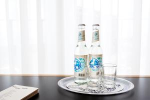 - deux bouteilles d'eau et des verres sur une table dans l'établissement Im-Jaich Hotel Bremerhaven, à Bremerhaven