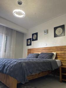 a bedroom with a bed with a wooden head board at Milez homes in Kampala