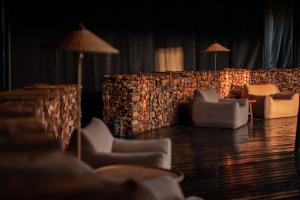 een kamer met stoelen en een stenen muur met verlichting bij Hongyuan Weilu Nomadic Luxury Camp in Hongyuan
