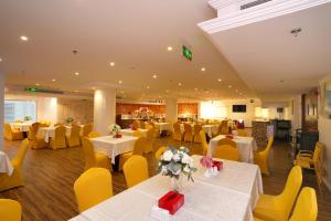 a banquet hall with white tables and yellow chairs at كازا فيزو للشقق المخدومة Casa Visio serviced Apartmenet in Jeddah
