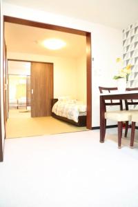 Un dormitorio con una cama y un espejo grande. en サンハウス 2, en Osaka