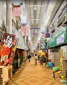 Un callejón en un centro comercial con carteles en los techos. en サンハウス 2, en Osaka