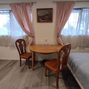 オークランドにあるQuiet 40m Studio - Kitchen, Washer, AC, Work Deskのダイニングルーム(椅子2脚、ベッド1台付)