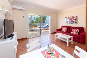 a living room with a red couch and a table at Apartamentos Terrazas Los Gigantes by Suncanarias in Acantilado de los Gigantes