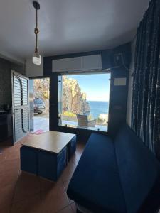 Una sala de estar con una mesa y vista al mar. en "Seaside Studio with Stunning Views in Belyounech, en Belyounech 