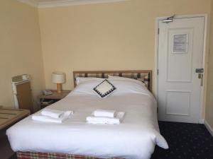 um quarto com uma cama branca e toalhas em Leeford Place Hotel em Battle