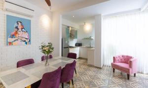 un soggiorno con tavolo e sedie viola di Vagator Royale 2BR Villa Near Vagator, Goa ad Assagao