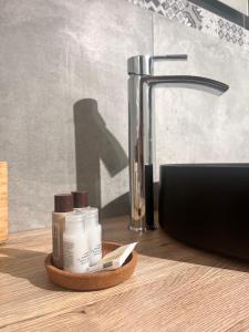 un ripiano del bagno con alcune creme idratanti e un lavandino di Buatta house a Catania