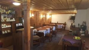 uma sala de jantar com uma mesa longa e cadeiras em Guest House Lina em Koprivshtitsa