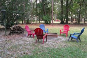 a group of colorful chairs sitting around a fire pit at Moody Woods in Orange Park