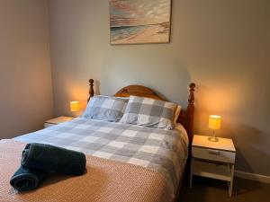 a bedroom with a bed with two night stands and two lamps at Rose Garden Retreat in Timboon