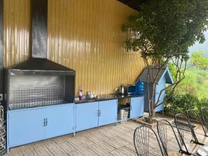 a kitchen with blue cabinets and a table and chairs at Le Soleil Ba Vì in Ba Vì