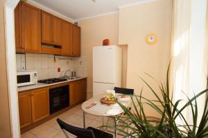 a kitchen with a table and a white refrigerator at TVST Apartments Mayakovskaya in Moscow