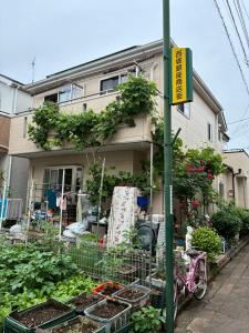a house with plants and a bike in front of it at Higashikurume station in Niiza City in Katayama