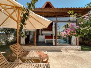 un patio con banco y sombrilla en Ocean Bay Retreat, en Bingin Beach 8 fotos más