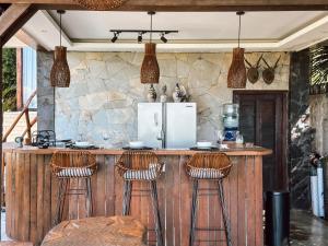 Una cocina con barra con taburetes y refrigerador. en Ocean Bay Retreat, en Bingin Beach