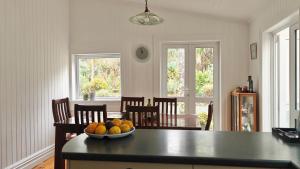 a kitchen with a bowl of fruit on a table at Top Hill House in Otuhi
