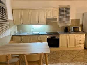 Una cocina con gabinetes blancos y una mesa con sillas. en Villa Flamingo, en Arguineguín