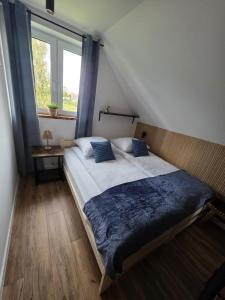 a bedroom with a large bed with a window at Górskie Zacisze in Mysłakowice +12 photos