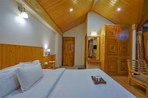 a bedroom with a large bed with a wooden ceiling at Timber Haven Villa 4BHK in Manāli